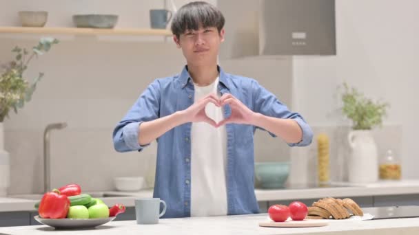 Asiático hombre fabricación corazón forma por manos mientras en cocina — Vídeos de Stock