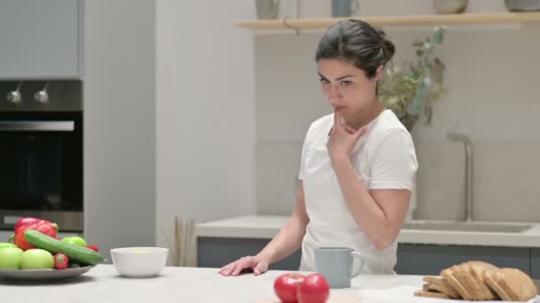 Mujer india sintiéndose preocupada mientras está parada en la cocina — Vídeo de stock