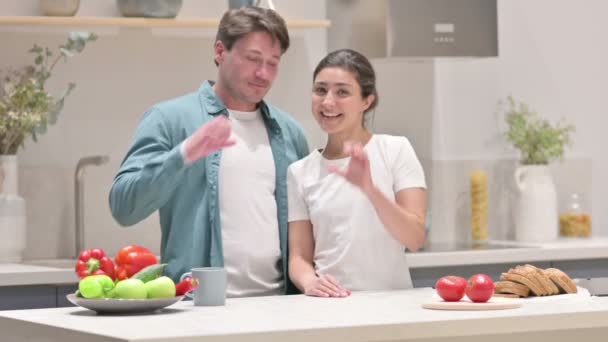 Coppia mista razza che fa forma di cuore da mani mentre in cucina — Video Stock