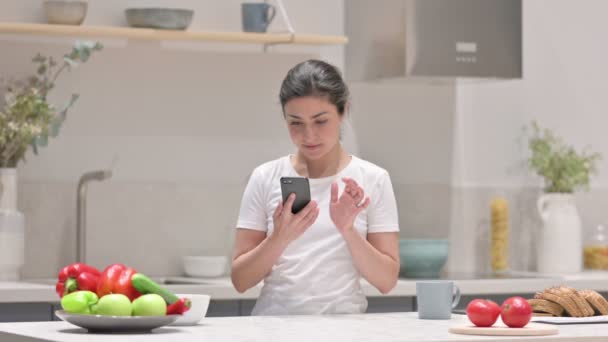 Femme indienne utilisant Smartphone sur tapis de yoga à la maison — Video