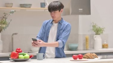 Asyalı Adam Mutfaktaki Akıllı Telefon 'da Meyve Fotoğrafı Çekiyor 
