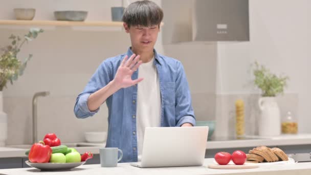 Asiatisk man gör video samtal på laptop i köket — Stockvideo