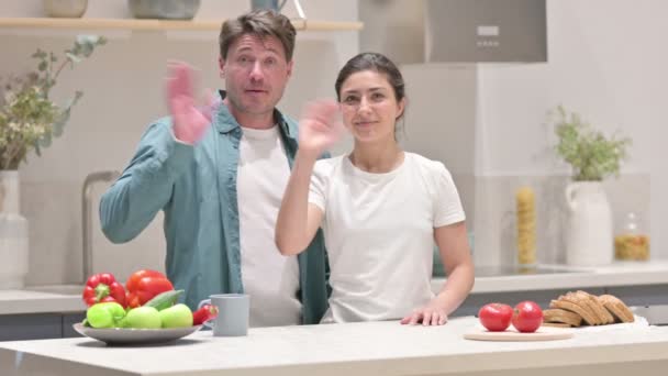 Pareja de raza mixta haciendo videollamada mientras está de pie en la cocina — Vídeos de Stock