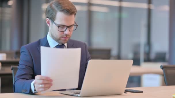 Empresario con Documentos de Lectura de Portátiles en la Oficina — Vídeo de stock