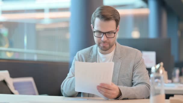 Hombre casual leyendo documentos en la oficina — Vídeo de stock