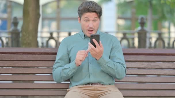 Úspěšný muž středního věku slaví na smartphonu — Stock video