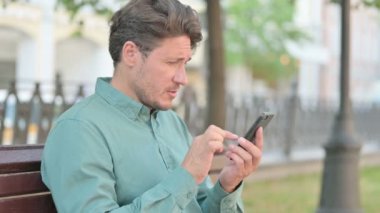 Smartphone on Bench 'te Erkek Bakışının Portresi