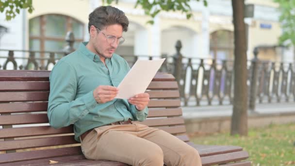 Homme bouleversé lors de la lecture de documents sur le banc du parc — Video