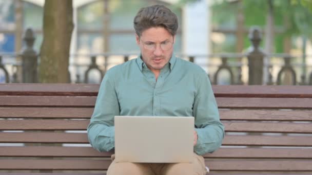 Hombre de mediana edad se siente enojado mientras usa el ordenador portátil — Vídeo de stock