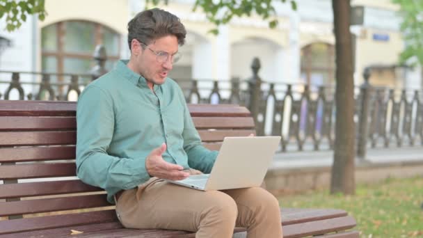 Muž cítí vztek při používání notebooku na lavičce — Stock video