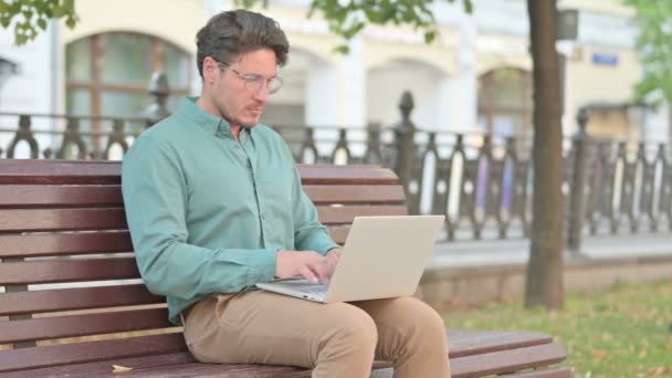 Man denken tijdens het werken op laptop op de bank — Stockvideo