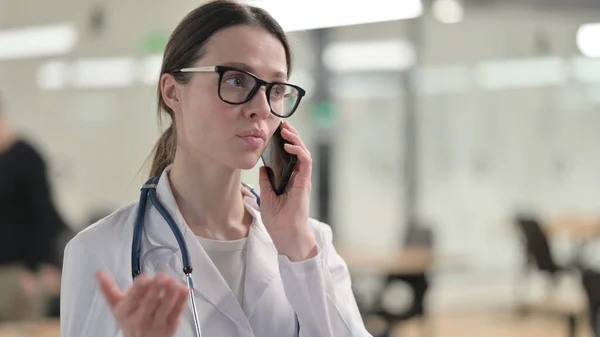 Portret młodej lekarki rozmawiającej przez telefon — Zdjęcie stockowe