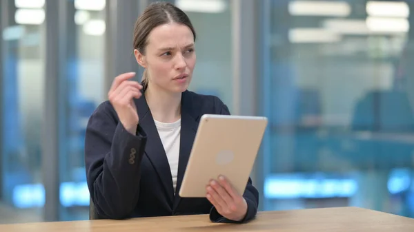 Video Call on Tablet vele gyönyörű fiatal üzletasszony a munkahelyen — Stock Fotó