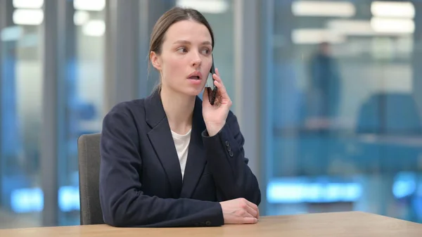 Giovane donna d'affari che parla al telefono sul lavoro — Foto Stock