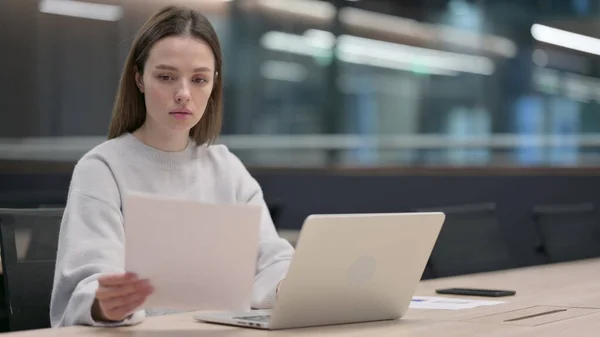 Kvinna Läsdokument medan du arbetar på laptop — Stockfoto