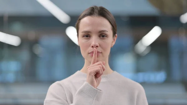 Portret van een vrouw met stil gebaar, vinger op de lippen — Stockfoto