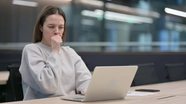 Жінка кашель під час використання ноутбука на роботі — стокове фото