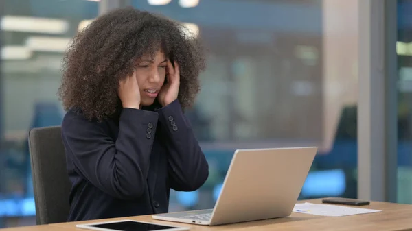 Afrikansk affärskvinna med bärbar dator som har huvudvärk — Stockfoto
