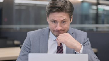 Gergin Orta Çağ İşadamı Dizüstü bilgisayarda çalışıyor 