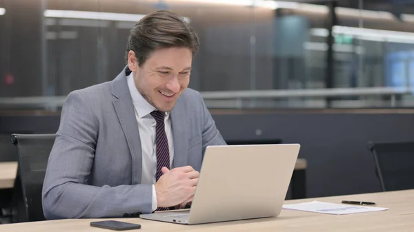 Appel vidéo sur ordinateur portable par un homme d'affaires du Moyen Âge au bureau — Photo