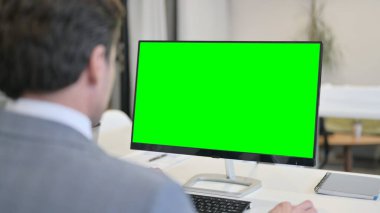 Yeşil Krom Anahtar Ekranı ile Masaüstü kullanan İşadamı 