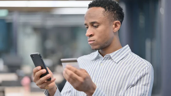 Porträt eines afrikanischen Geschäftsmannes, der Online-Zahlungen mit dem Smartphone macht — Stockfoto