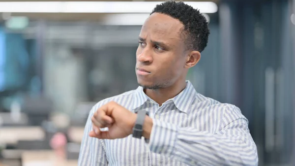 Portrait d'un homme d'affaires africain regardant une montre intelligente, en attente — Photo