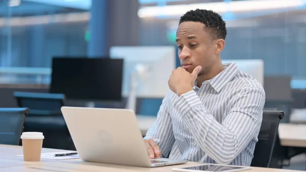 Junger afrikanischer Geschäftsmann mit Laptop bei der Arbeit — Stockfoto