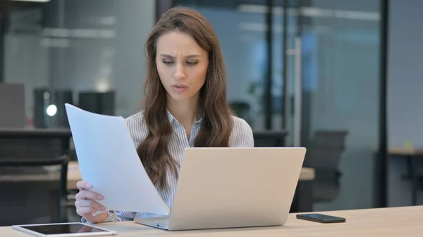 Ung affärskvinna med bärbar dator reagera på misslyckande med dokument — Stockfoto