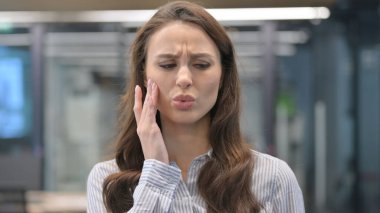 Diş ağrısı çeken genç iş kadınının portresi.