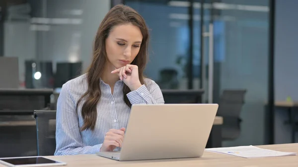 Fiatal üzletasszony Gondolkodás használata közben Laptop a munkahelyen — Stock Fotó