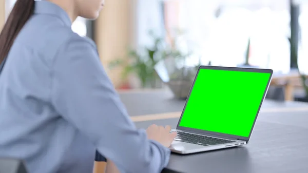 Mujer latina usando el ordenador portátil con la pantalla dominante verde del croma — Foto de Stock