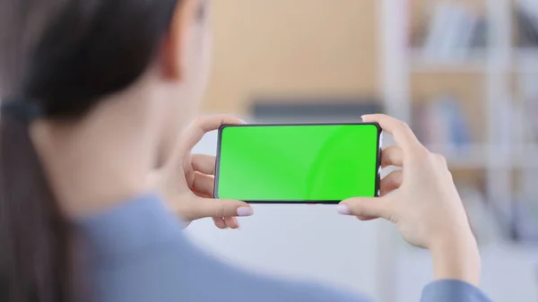 Latinská žena při pohledu na Smartphone se zelenou Chroma Key Screen — Stock fotografie