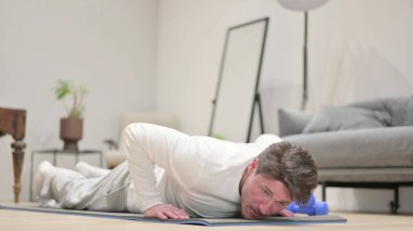 Orta yaşlı adam evde şınav çekiyor.