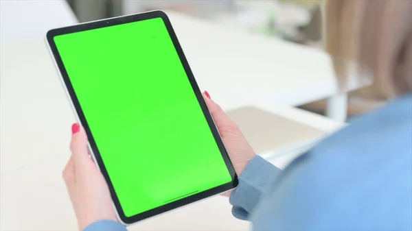 Žena drží tabletu se zelenou obrazovkou, posmívat se — Stock fotografie