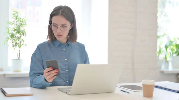 Dizüstü bilgisayarlı bir kadın iş yerinde interneti tarıyor. — Stok fotoğraf