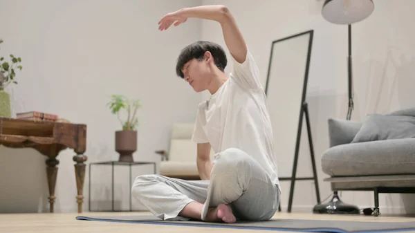 Ung asiatisk man gör Stretches hemma — Stockfoto