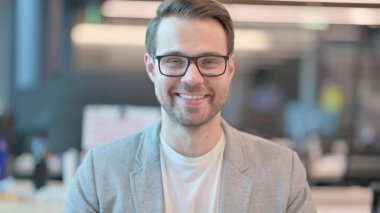 Kameraya gülümseyen genç adamın portresi 