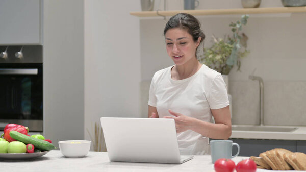 Young Indian Woman doing Video Call on Laptop in Kitchen