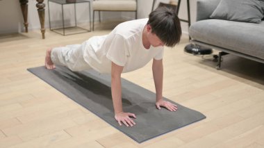 Evde şınav çeken genç bir Asyalı.