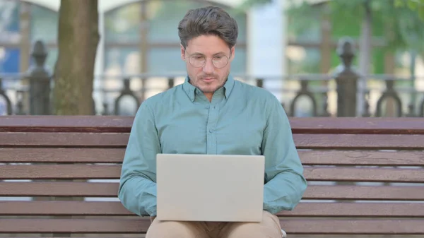 Ο άνθρωπος που εργάζεται σε φορητό υπολογιστή, ενώ κάθεται Εξωτερική — Φωτογραφία Αρχείου