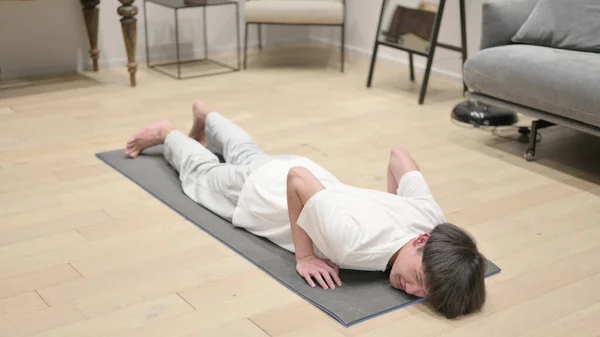 Tired Asian Man Lying on Excercising mat at Home