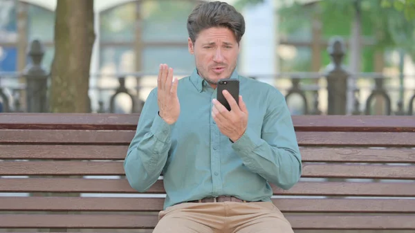 Людина реагує на втрати на смартфоні — стокове фото