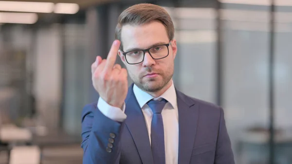 Retrato de un joven empresario mostrando el signo del dedo medio — Foto de Stock