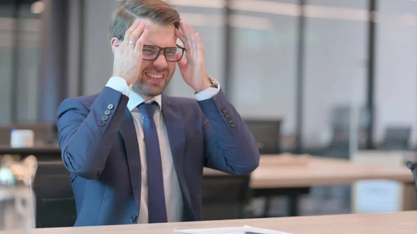 Ung affärsman med huvudvärk i moderna kontoret — Stockfoto