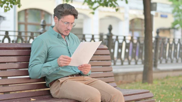 ベンチの屋外で座っている間に成熟した大人の男読書文書 — ストック写真