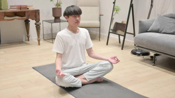 Ung asiatisk man mediterar hemma — Stockfoto