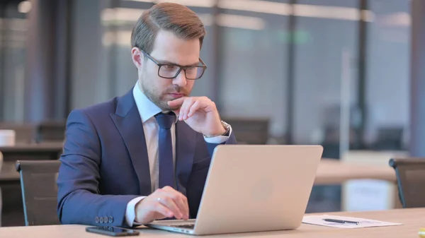 Joven Empresario con Pensamiento Portátil en el Trabajo — Foto de Stock