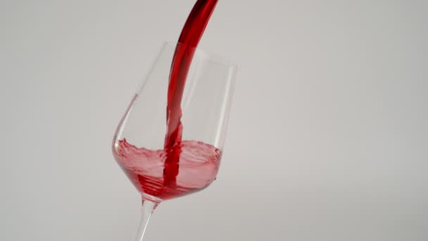 Super powolny ruch nalewania czerwonego wina w szkle przy 1000 fps, białe tło — Wideo stockowe