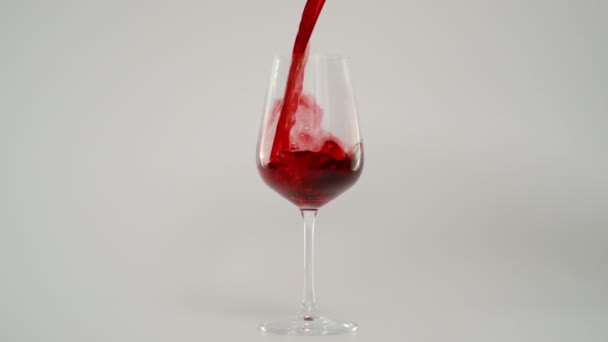 Медленное движение Pooring Red Wine in Glass со скоростью 1000 кадров в секунду, Красный фон — стоковое видео